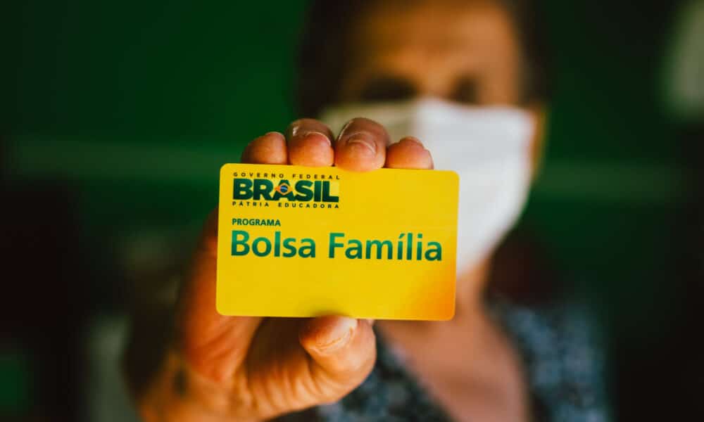 homem segurando cartão do bolsa família