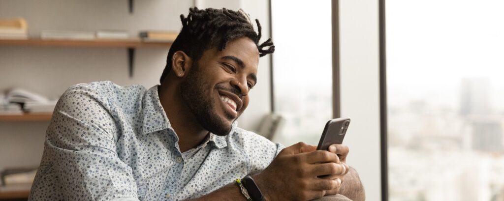 homem sorrindo olhando para o celular